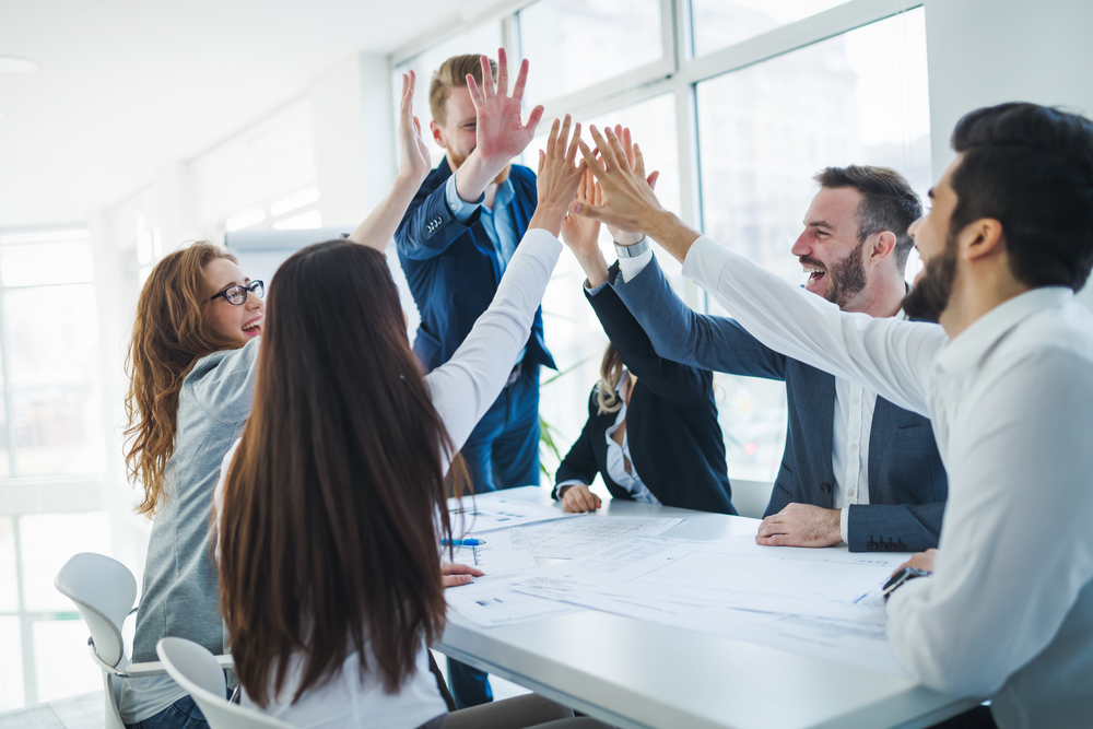 team members high five each other for motivation